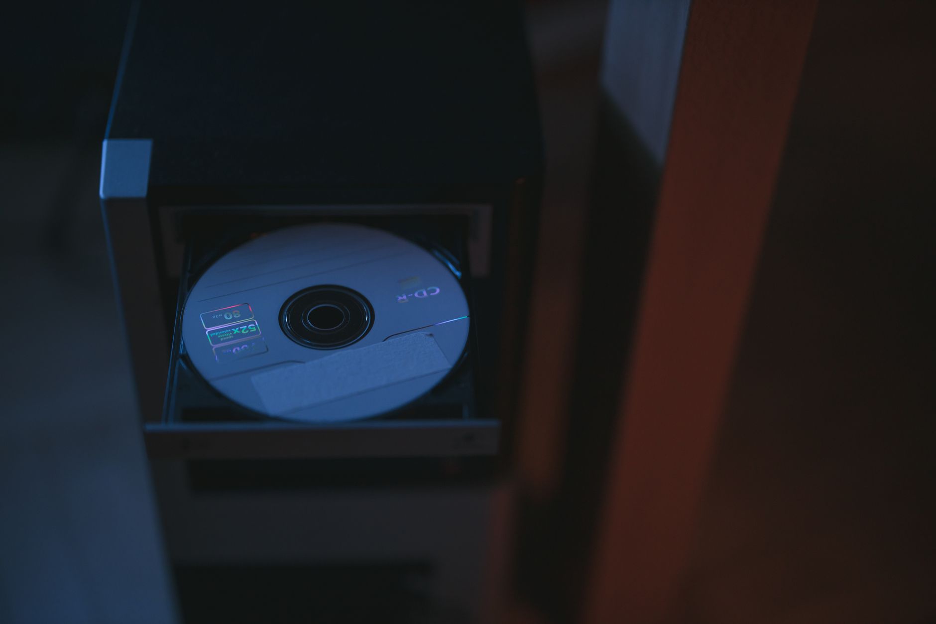 Old desktop computer with blank CDs representing online music piracy UK history Napster era