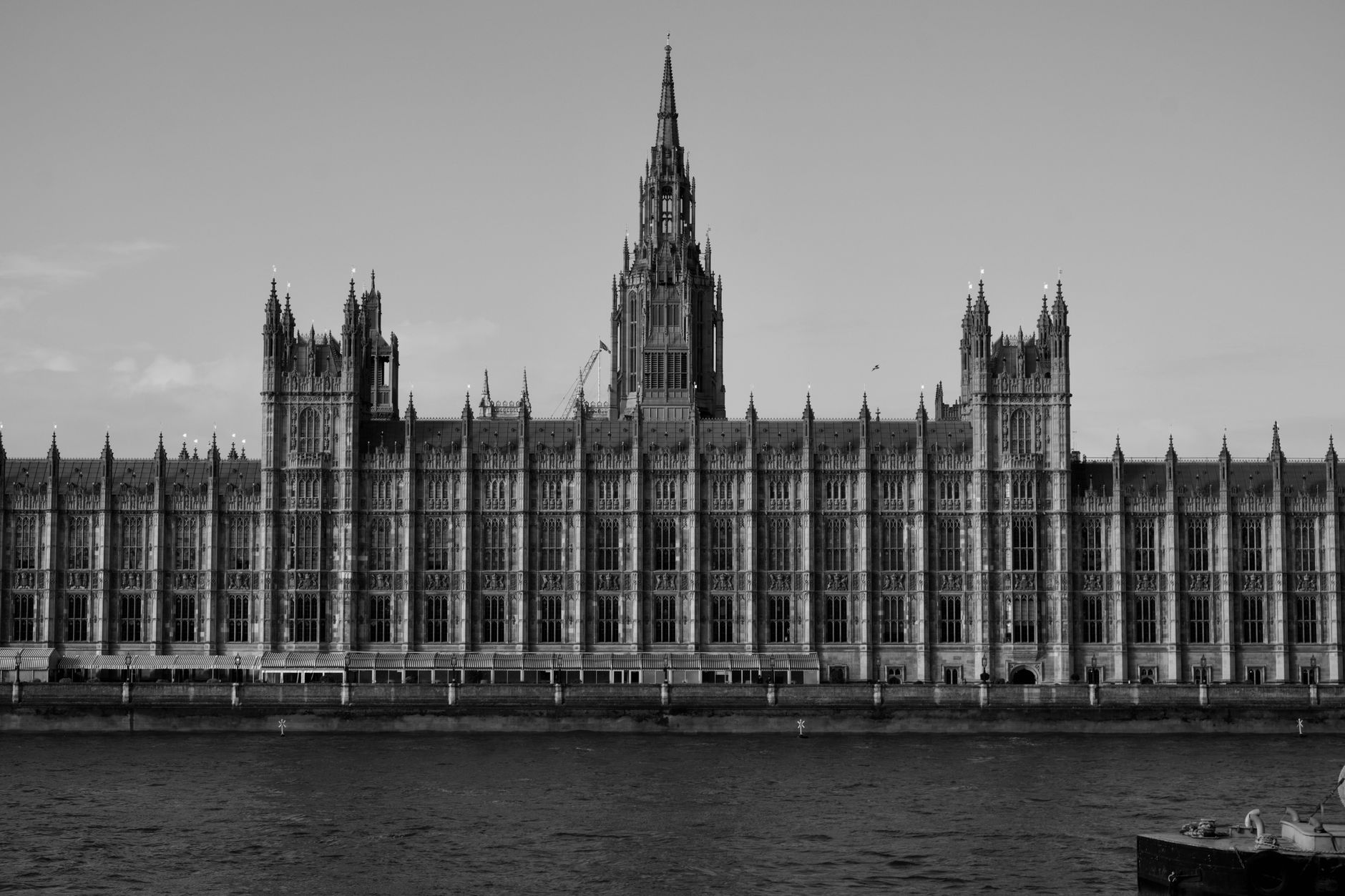 The Houses of Parliament reflected in the Thames, representing the legislative history behind Ofcom internet regulation in the UK